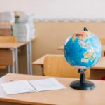 school table with globe notebook pen
