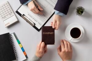 Hands exchanging a passport during a visa application.