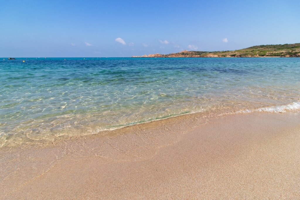 Turquoise waves on a golden sandy beach under a blue sky